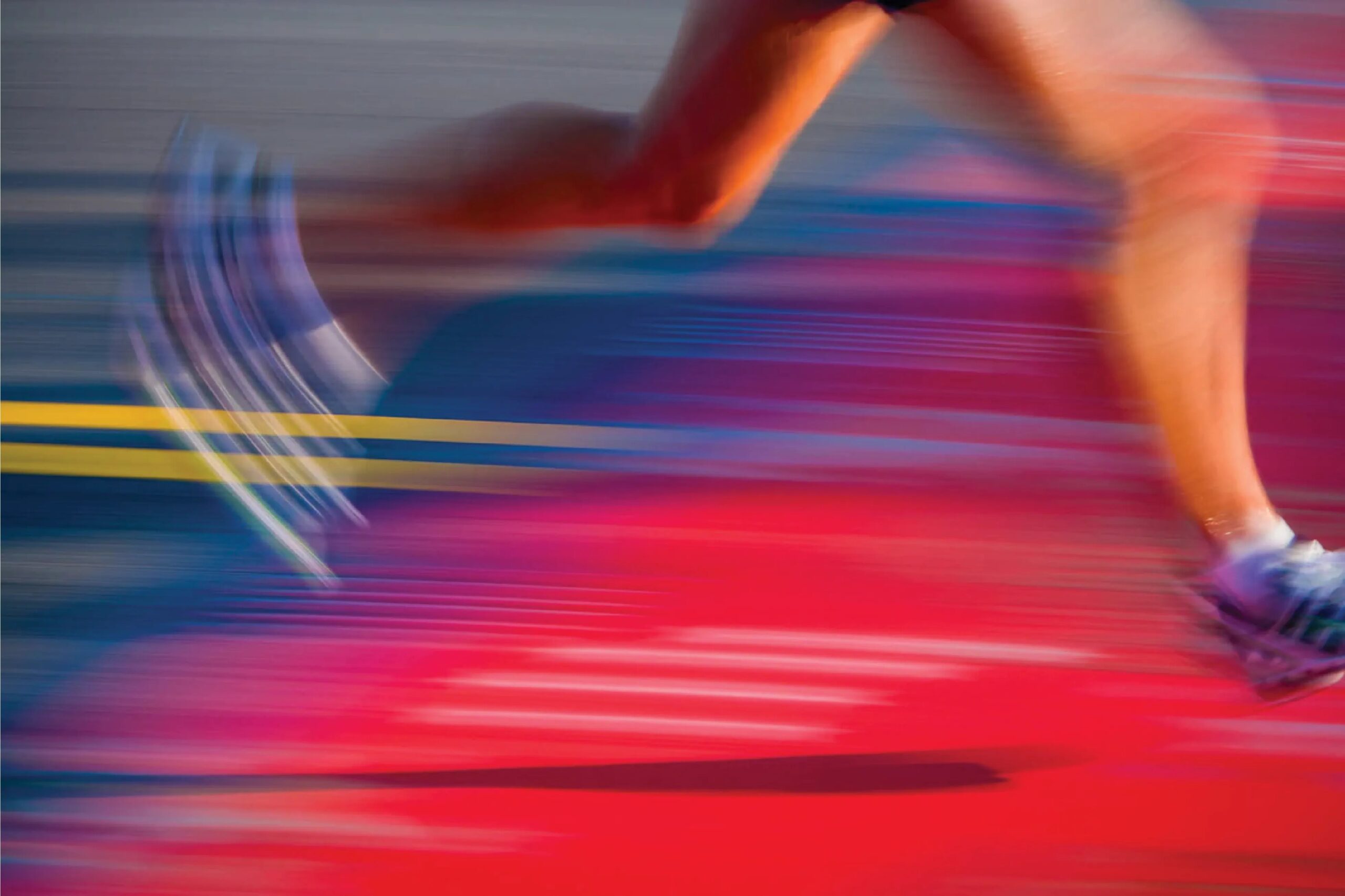 A runner in motion, captured as a blur against a warm orange backdrop